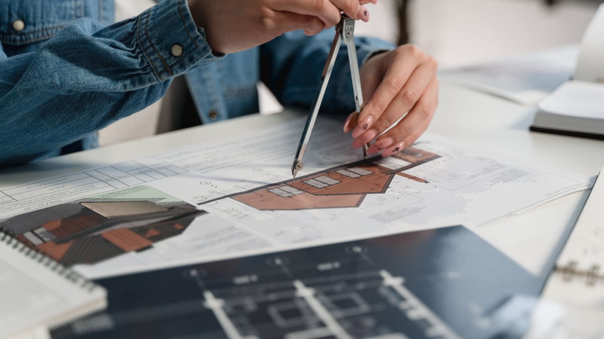 Architect working on plans and a model